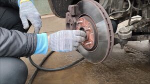 Mechanic inspecting brake pads for wear indicators at auto repair shop