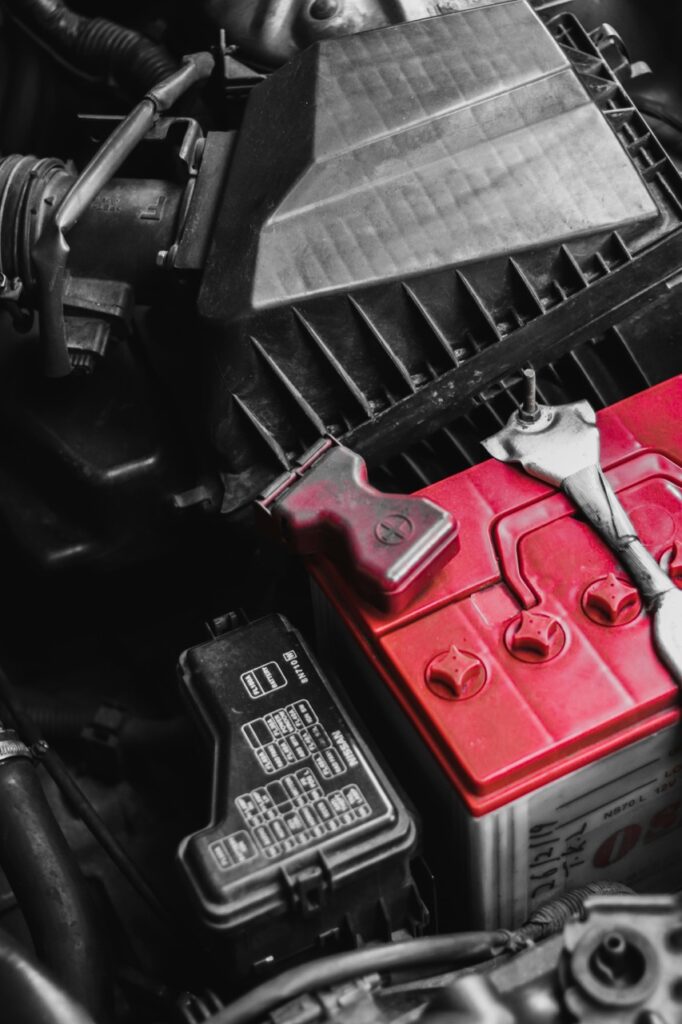Detailed view of car battery and engine parts with wrench, focusing on repair and maintenance
